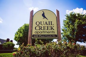 Amarillo apartment for rent - a sign for quail creek apartments in front of trees