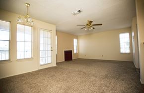 Amarillo apartment for rent - an empty living room with a ceiling fan and windows
