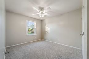 Jacksonville house for rent - A room with a ceiling fan and a window showing a view of trees.