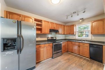 Jacksonville house for rent - A kitchen with wooden cabinets and a stainless steel refrigerator.