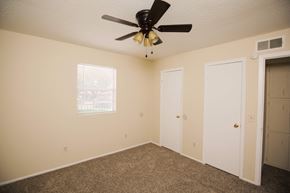 Amarillo apartment for rent - a bedroom with a ceiling fan and a door