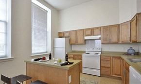 York apartment for rent - a kitchen with wooden cabinets and white appliances