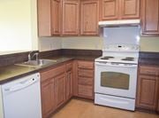 Elkton apartment for rent - a kitchen with white appliances and wooden cabinets