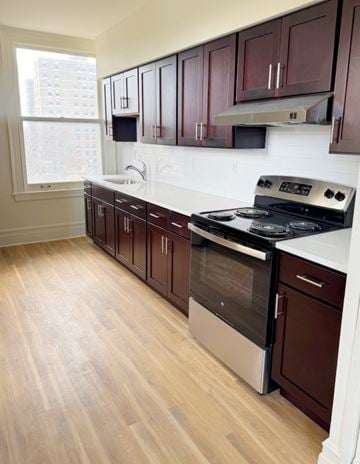 Jersey City apartment for rent - A kitchen with dark wood cabinets and a white counter.