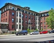 Jersey City apartment for rent - a large brick building with cars parked in front