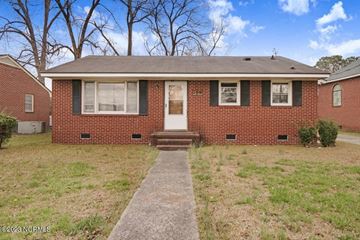 Goldsboro house for rent - A red brick house with a white door and black shutters.