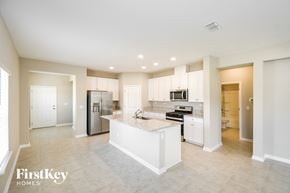 Yulee house for rent - a large kitchen with white cabinets and stainless steel appliances