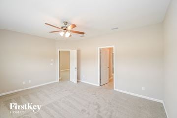 Yulee house for rent - a spacious living room with carpet and a ceiling fan