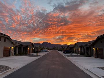Apache Junction apartment for rent - A street in a residential area with houses on both sides and a mountain in the distance.