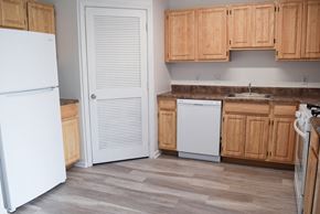 Farmingdale apartment for rent - a kitchen with wooden cabinets and a white refrigerator