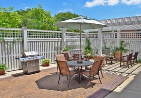 Perth Amboy apartment for rent - a patio with a table and chairs and a grill