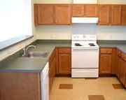Perth Amboy apartment for rent - an empty kitchen with wooden cabinets and white appliances