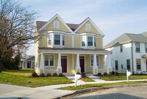 Pleasantville apartment for rent - a yellow house with red doors and a sidewalk