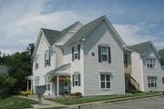 Landing townhouse for rent - a white house with white siding  and a street