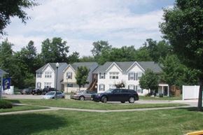 Landing townhouse for rent - a group of cars parked in front of houses