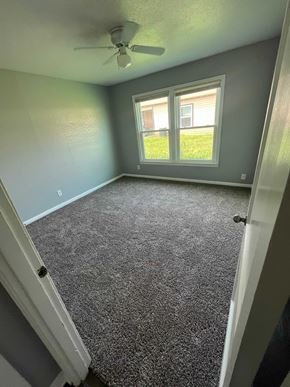 Killeen apartment for rent - A room with a ceiling fan and a carpeted floor.
