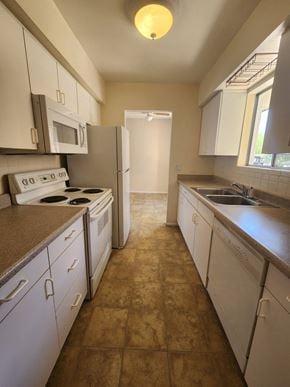 Tucson house for rent - an empty kitchen with white appliances and counters