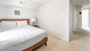 Washington apartment for rent - a bedroom with a large white bed and a hallway