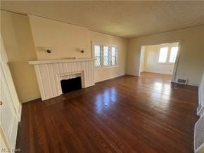 Shaker Heights apartment for rent - an empty living room with a fireplace and wooden floors