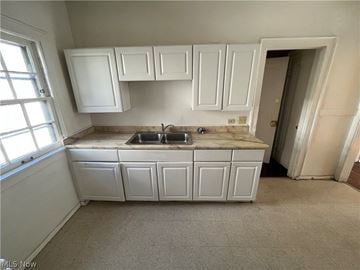 Shaker Heights apartment for rent - an empty kitchen with white cabinets and a sink