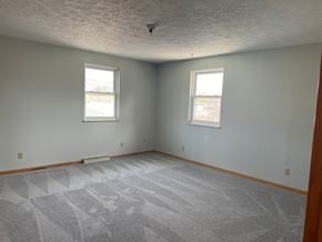 Canton apartment for rent - A room with a grey carpet and two windows.