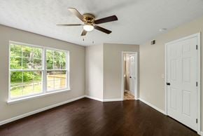 Louisville house for rent - an empty living room with a ceiling fan and a window
