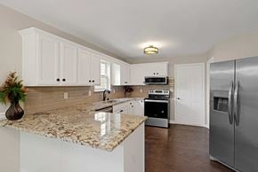 Louisville house for rent - a kitchen with a granite counter top and a stainless steel refrigerator