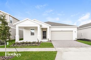 Kissimmee house for rent - a white house with a driveway and a garage door
