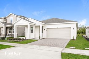 Kissimmee house for rent - a white house with a driveway and a garage door