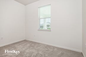 Kissimmee house for rent - a bedroom with a window and white walls and carpet