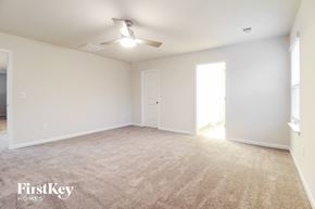 Greenville house for rent - a spacious living room with white walls and a ceiling fan