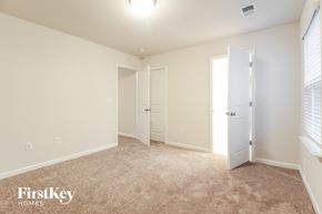 Greenville house for rent - a bedroom with white walls and carpet and a door to a closet