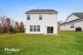 Greenville house for rent - the back of a white house with a grassy yard