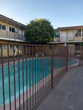 N. Hollywood apartment for rent - the pool is behind a fence in front of an apartment building