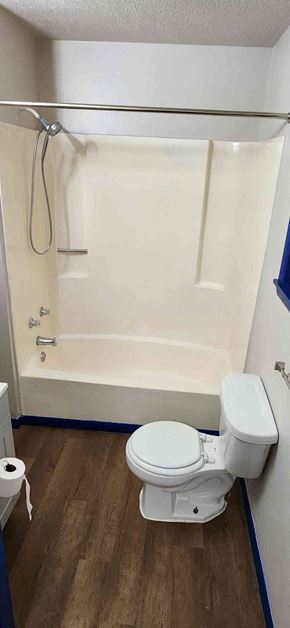 Windsor house for rent - A white toilet sits next to a white bathtub in a small bathroom.