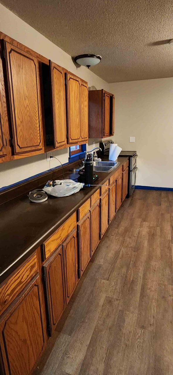 Windsor house for rent - A kitchen with wooden cabinets and a black countertop.