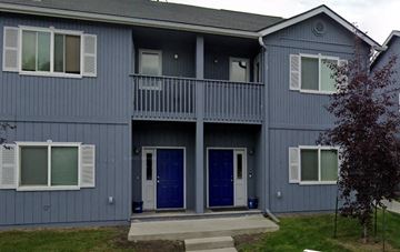 Anchorage apartment for rent - A grey two story house with a balcony and blue doors.