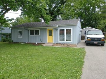 Cincinnati house for rent - a blue house with a yellow door and a truck parked in the driveway