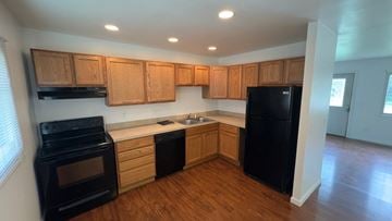 Cincinnati house for rent - a kitchen with black appliances and wooden cabinets