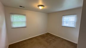 Cincinnati house for rent - a bedroom with a carpeted floor and two windows