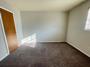 Clarksville apartment for rent - A room with a carpeted floor and a wooden door.