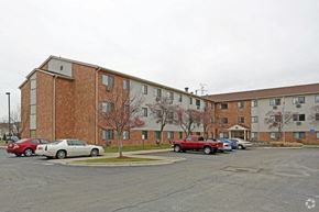 Harrison Twp apartment for rent - a parking lot with cars in front of an apartment building