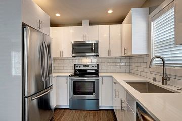 Seattle apartment for rent - a kitchen with white cabinets and stainless steel appliances