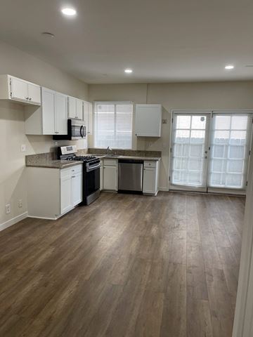 N. Hollywood apartment for rent - a kitchen with white cabinets and a wood floor