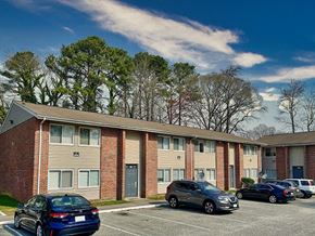 Newport News apartment for rent - an apartment building with cars parked in a parking lot