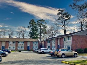 Newport News apartment for rent - a parking lot with cars in front of an apartment building
