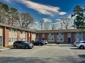 Newport News apartment for rent - an apartment building with cars parked in a parking lot