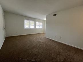 Newport News apartment for rent - an empty living room with carpet and a window