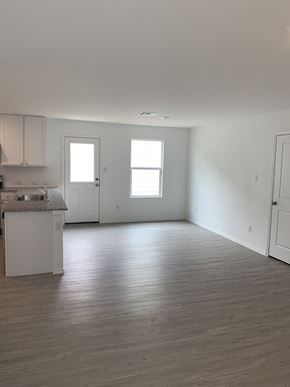 San Antonio house for rent - an empty kitchen and living room with white walls and wood floors
