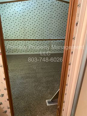 Andrews house for rent - A mirror reflecting a room with a green carpet and a wallpapered wall.